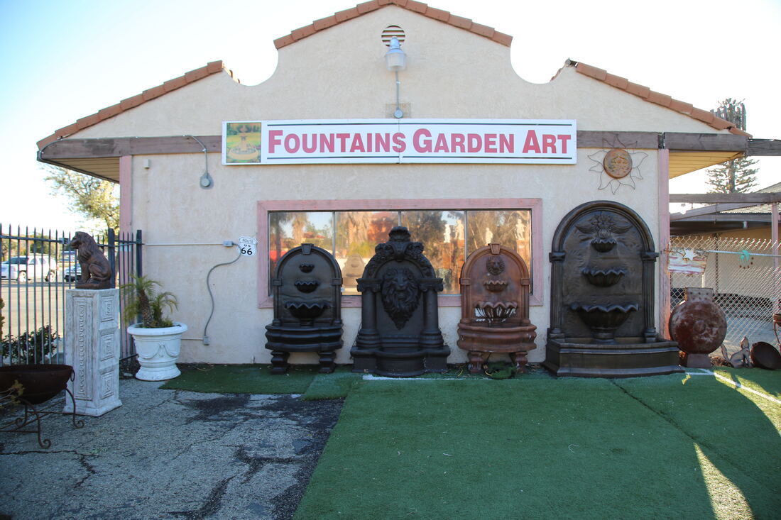 The Fountains Garden Art storefront with its red and white sign above the showroom doors.