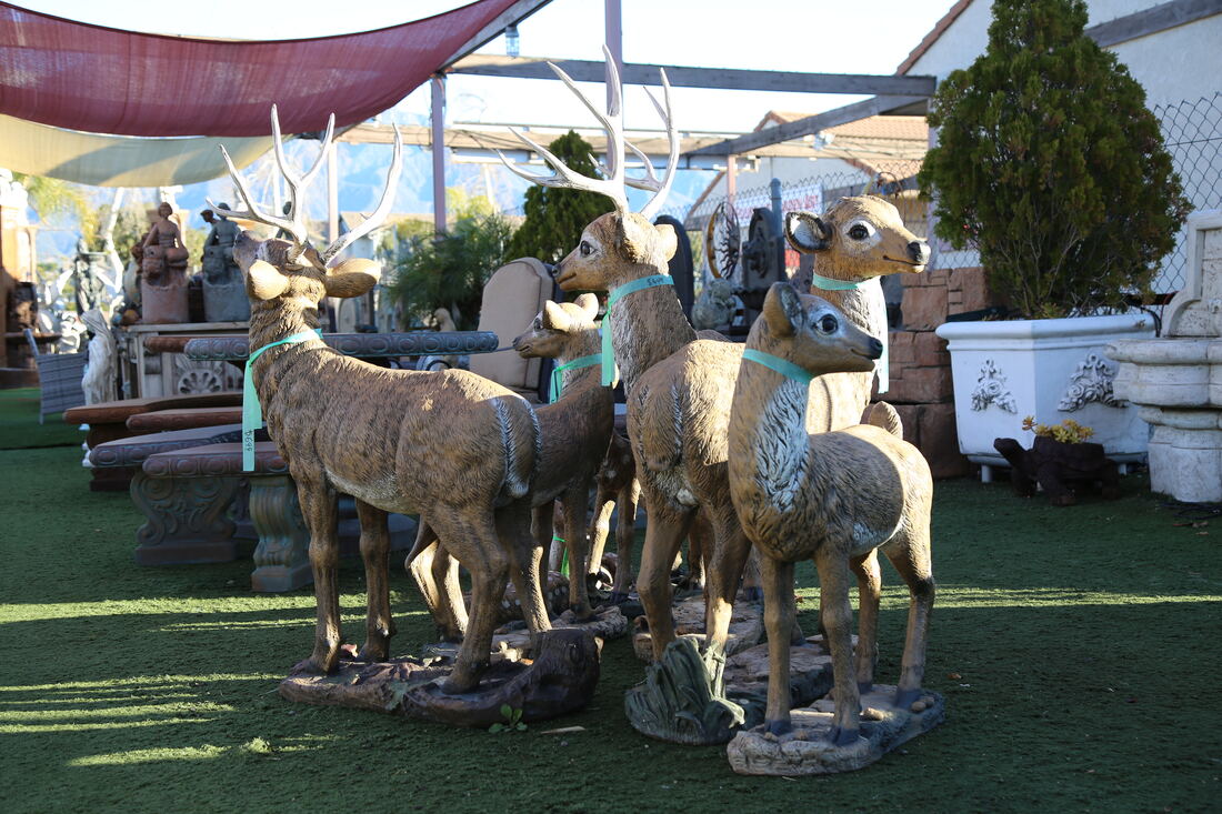 A group of life-size cast deer statues on the artificial turf.